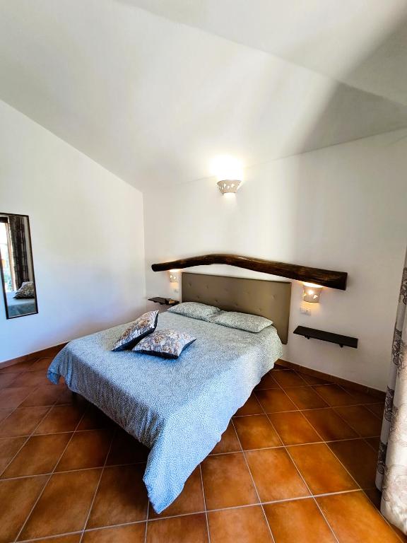 a bedroom with a bed in a white room at Yellon House in Santa Maria Navarrese