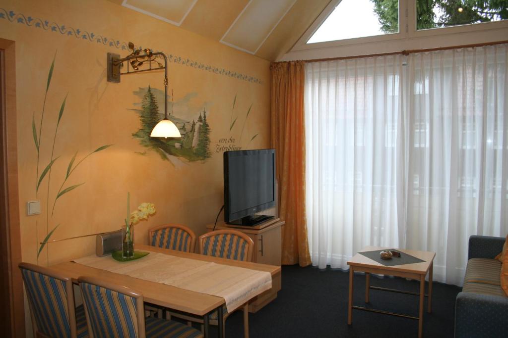 a living room with a table and a tv at Cafe Steffens in Hahnenklee-Bockswiese