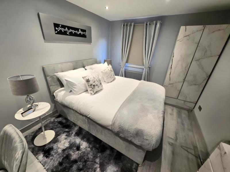 a bedroom with a king sized bed and a chair at DYNASTAYS- Stylish Seaside Home- Adults Only, Dog Friendly, Garden & Parking in Edinburgh