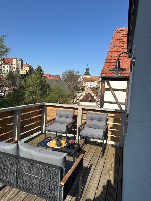 a balcony with two chairs and a table on a deck at Burgblick am Malerweg in Hohnstein
