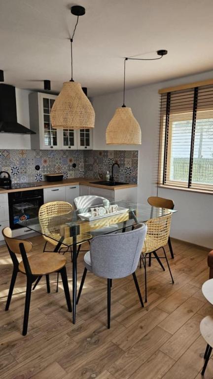 a kitchen and dining room with a table and chairs at Dom letniskowy do wynajęcia z własną Przystanią nad rzeką Narew - linia brzegowa in Dzbenin