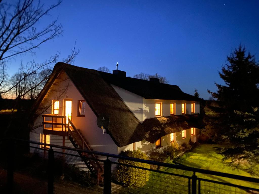 a house with its lights on at night at SIEDLISKO GąSKA in Maszewko