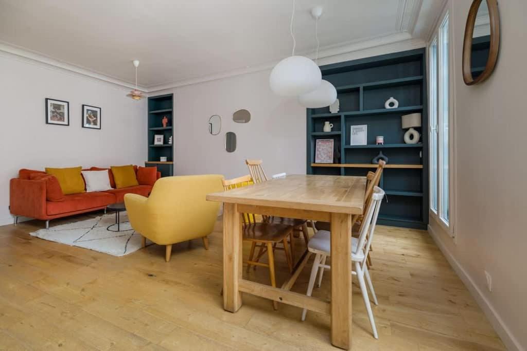 - un salon avec une table en bois et des chaises jaunes dans l'établissement 8 Joubert - 3BDR Galeries Lafayette, à Paris