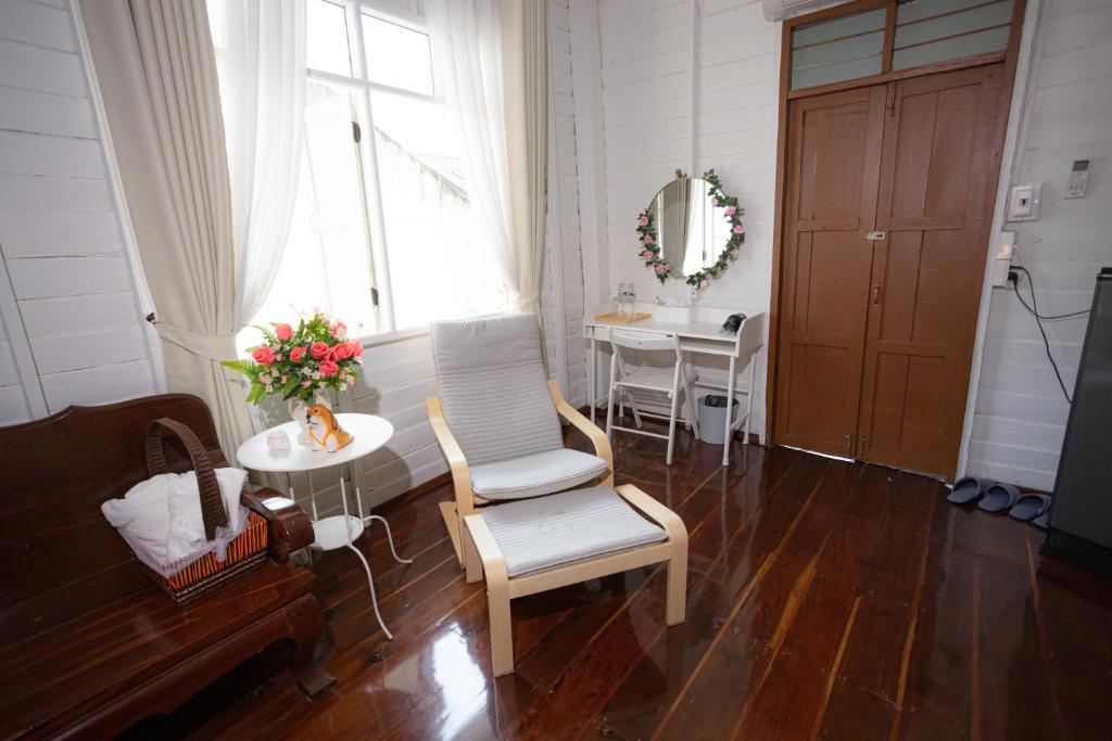 a living room with a chair and a table and a window at บ้านแสนรัก Casa Dolce Casa, Prakhon Chai in Prakhon Chai