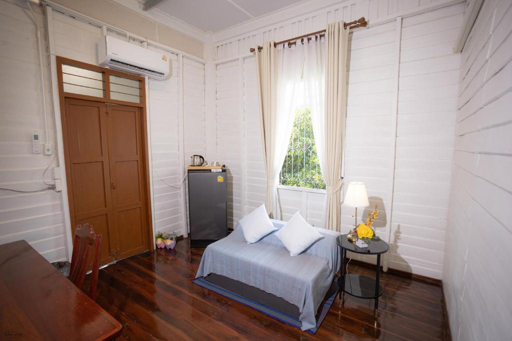 a bedroom with a bed and a table and a window at บ้านแสนรัก Casa Dolce Casa, Prakhon Chai in Prakhon Chai