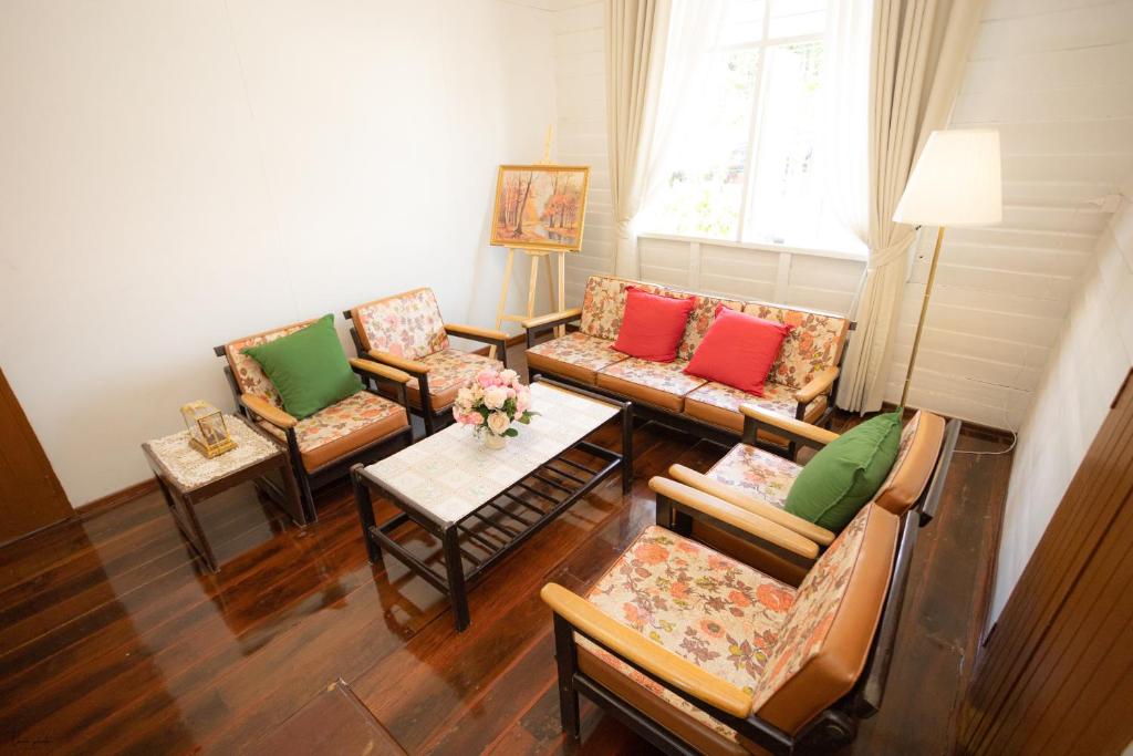 a living room with couches and tables and a window at บ้านแสนรัก Casa Dolce Casa, Prakhon Chai in Prakhon Chai