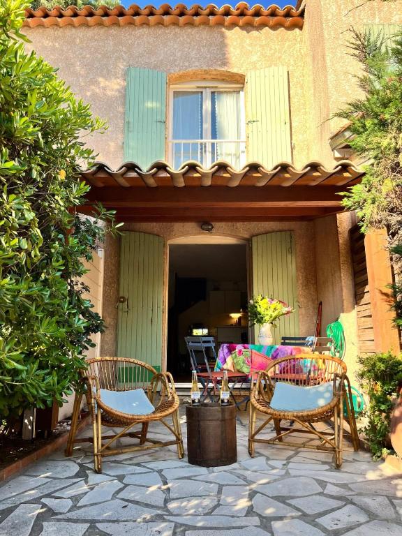 un patio avec des chaises et une table devant un bâtiment dans l'établissement Joli Mazet, T2-3 proche centre ville, à Sainte-Maxime