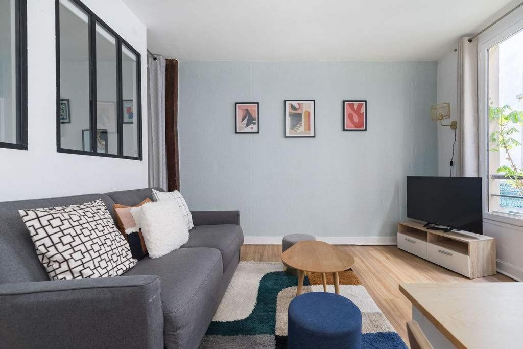 un salon avec un canapé et une télévision dans l'établissement Greneta - Spacious Flat Montorgueuil 4PAX, à Paris