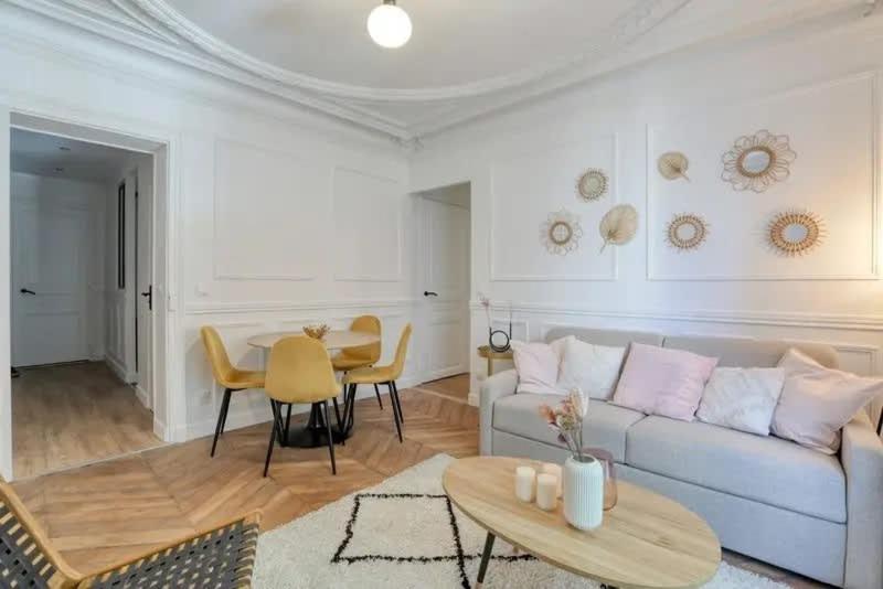 un salon avec un canapé et une table dans l'établissement Chapelle - Appartement familial au centre de Paris, à Paris