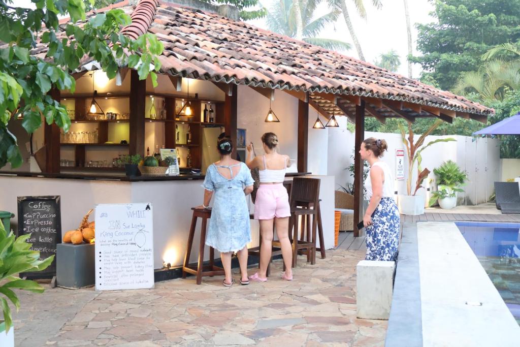 a group of three women standing in front of a bar at Handagedara Resort & Spa in Mirissa