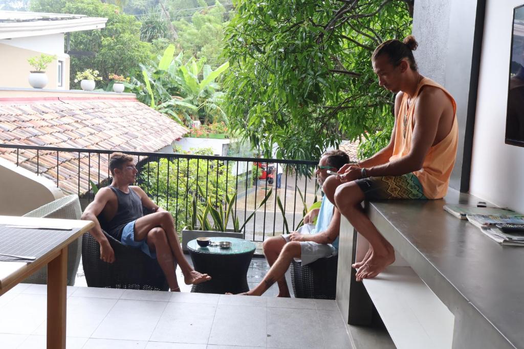 a group of three men sitting on a counter at Handagedara Resort & Spa in Mirissa