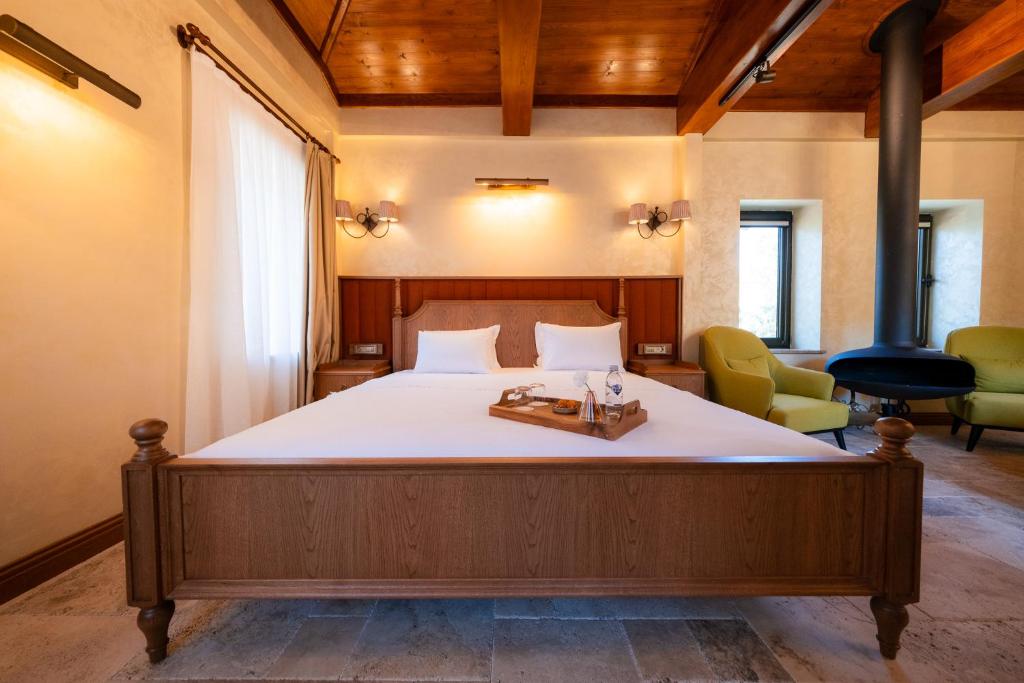 a bedroom with a large bed and two chairs at Casa Mila Kazdağları in Büyükçetmi