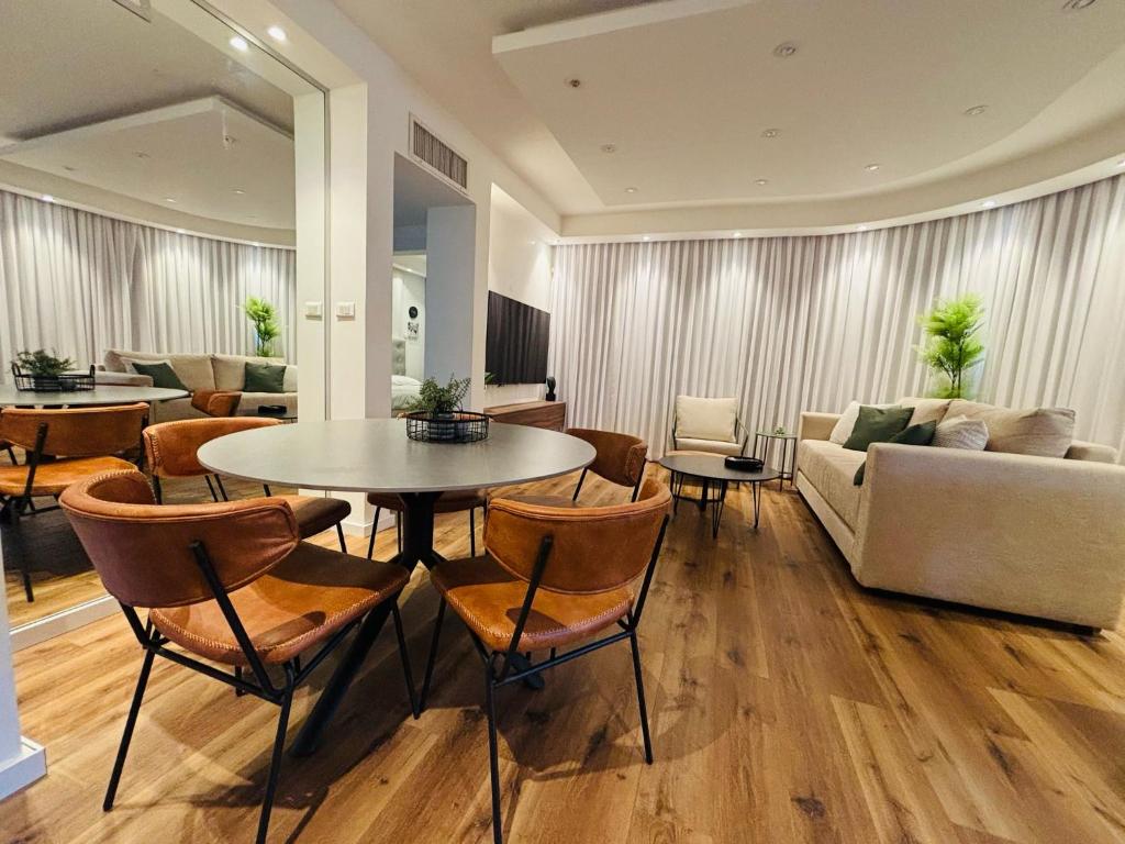 Una sala de estar con una mesa y sillas y un sofá. en Golf Residence Suite & pool, en Eilat