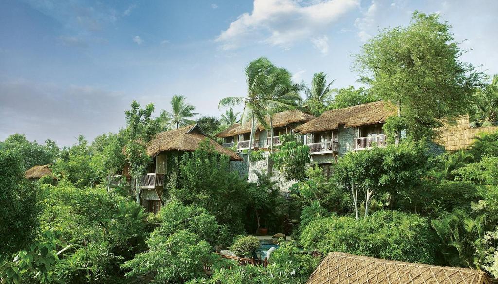 a group of houses in the jungle with trees at Taj Green Cove Resort and Spa Kovalam in Kovalam