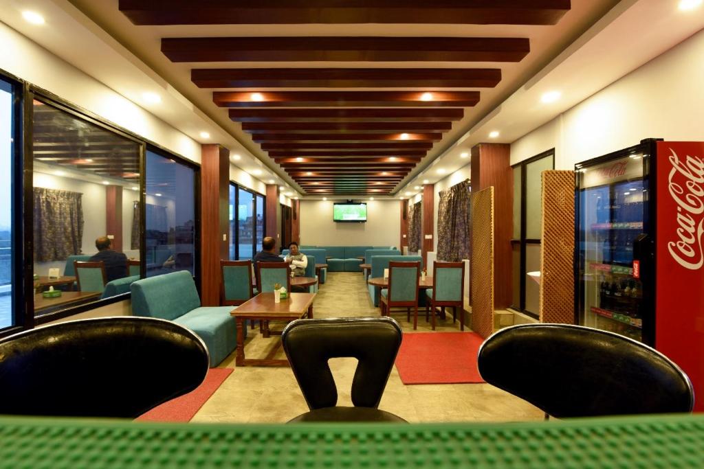 a waiting room with chairs and a table in a restaurant at Hotel Harmony in Kathmandu