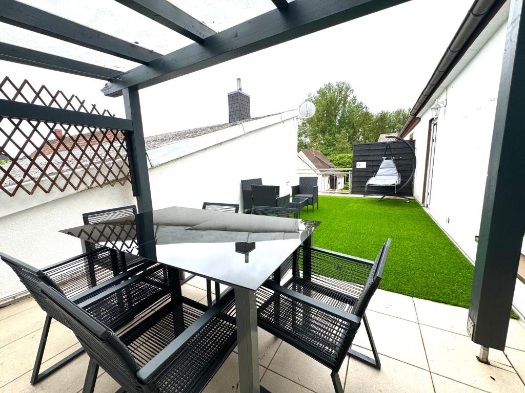 a patio with a table and chairs on a balcony at Maisonette Apartment mit Panorama Terrasse in Kaiserslautern WeHome Premium in Kaiserslautern