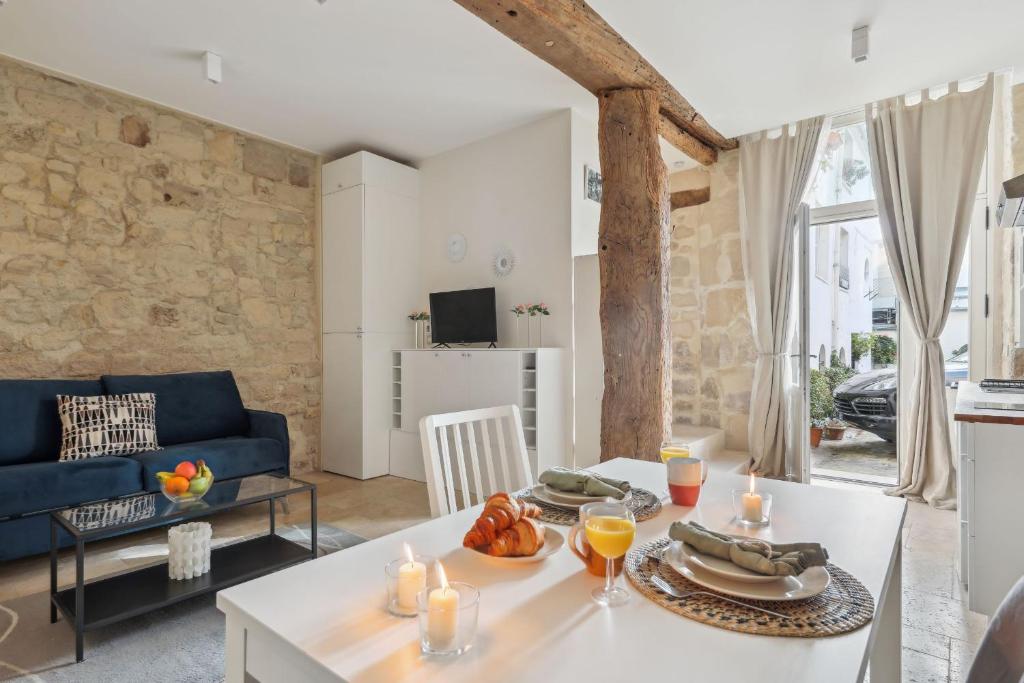 - un salon avec une table blanche et un canapé bleu dans l'établissement BnBNova - Ile St Louis, à Paris