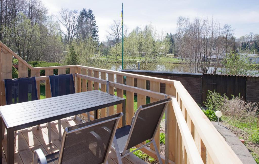 a wooden deck with a table and chairs at Ferienwohnung am See-Neu mit Balkon in Friedersdorf
