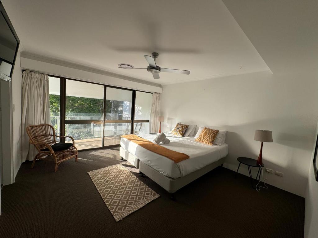 Un dormitorio blanco con una cama y una ventana. en Le Court Villas, en Noosa Heads