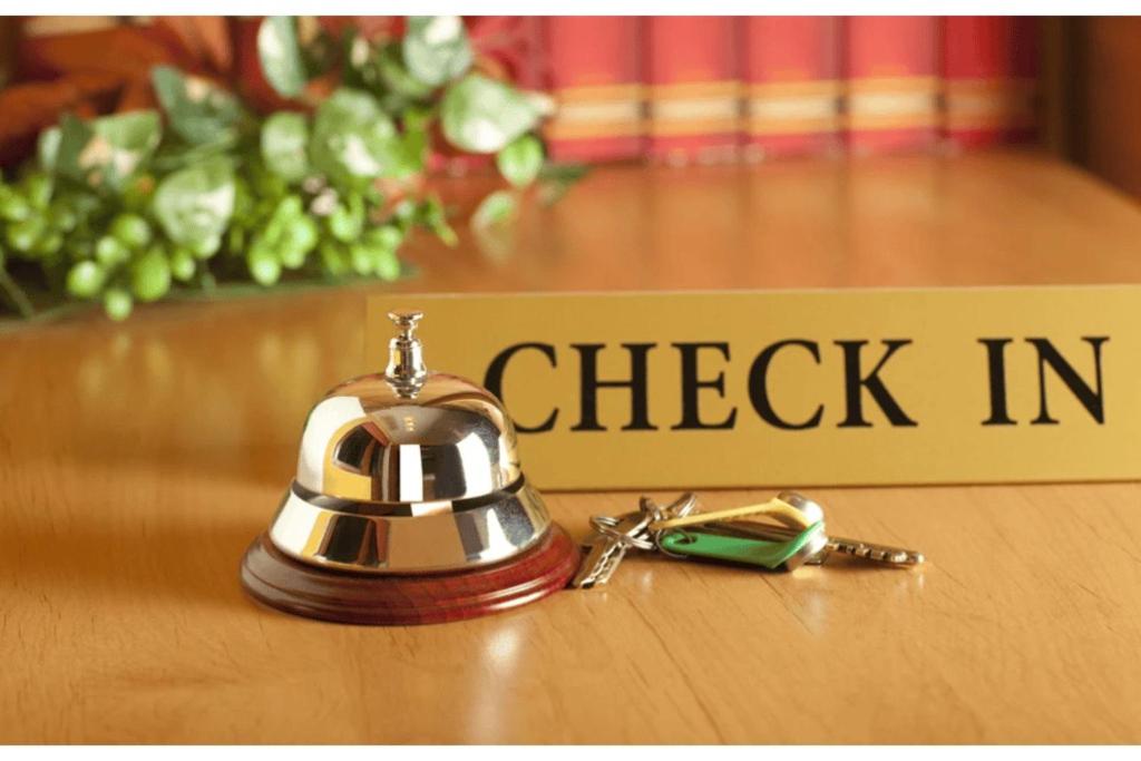 a bell sitting on a table next to a check in sign at Uday Homestay in Rāmpur
