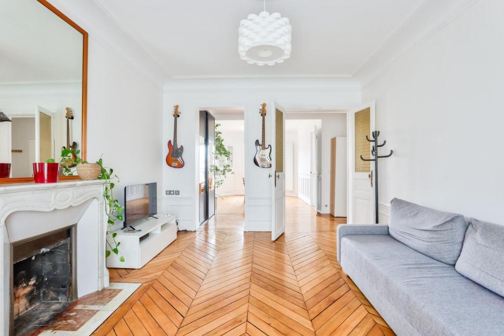 un salon avec un canapé et une cheminée dans l'établissement GuestReady - Family Retreat near Paris, à Saint-Denis