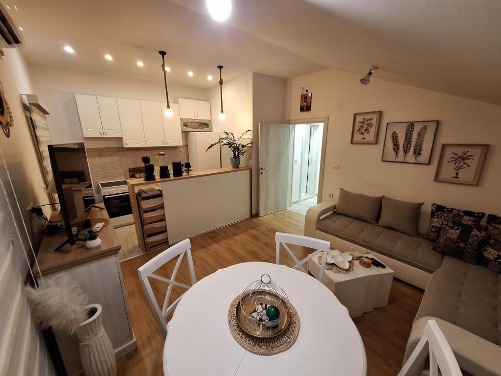 a living room with a white table and a kitchen at Vavic 1 in Španjola