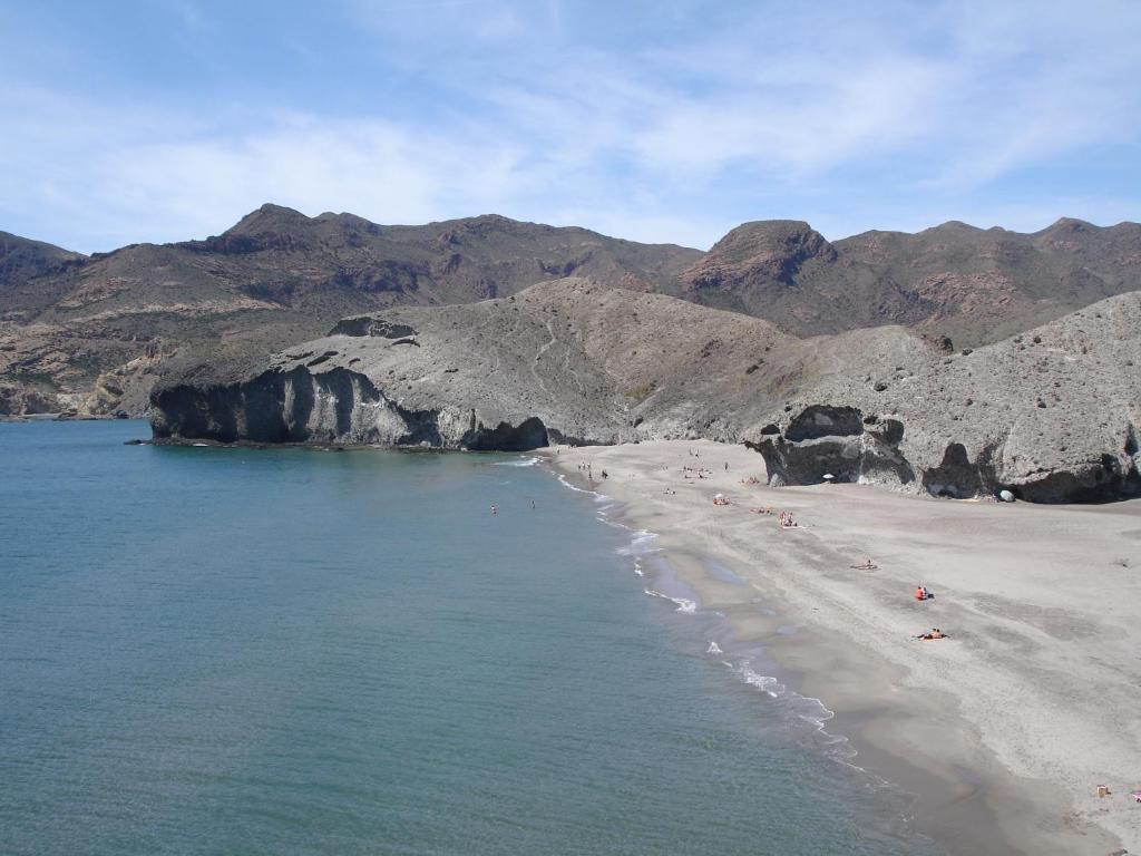 a beach with a bunch of people on the sand at Hostal El Dorado in San José