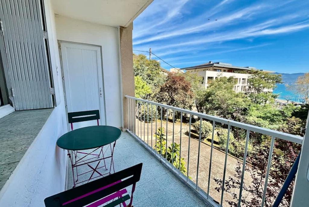 un balcon avec une chaise et une vue sur l'océan dans l'établissement Grand T3 avec vue mer - Proche plage - Parking & AC, à Ajaccio