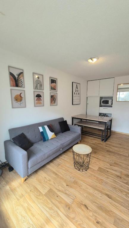 un salon avec un canapé et une table dans l'établissement Chez Florie - Résidence Les Cimes à la Foux d'Allos 6 couchages piscine sauna et hammam, à La Foux d'Allos