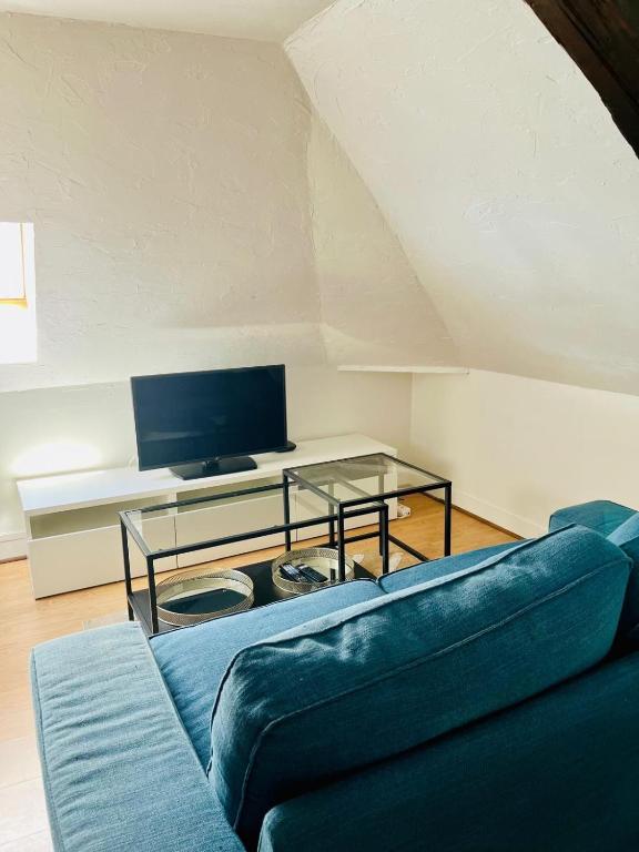 un salon avec un canapé bleu et une table en verre dans l'établissement Dalikyda - La Perle de Montivilliers, à Montivilliers