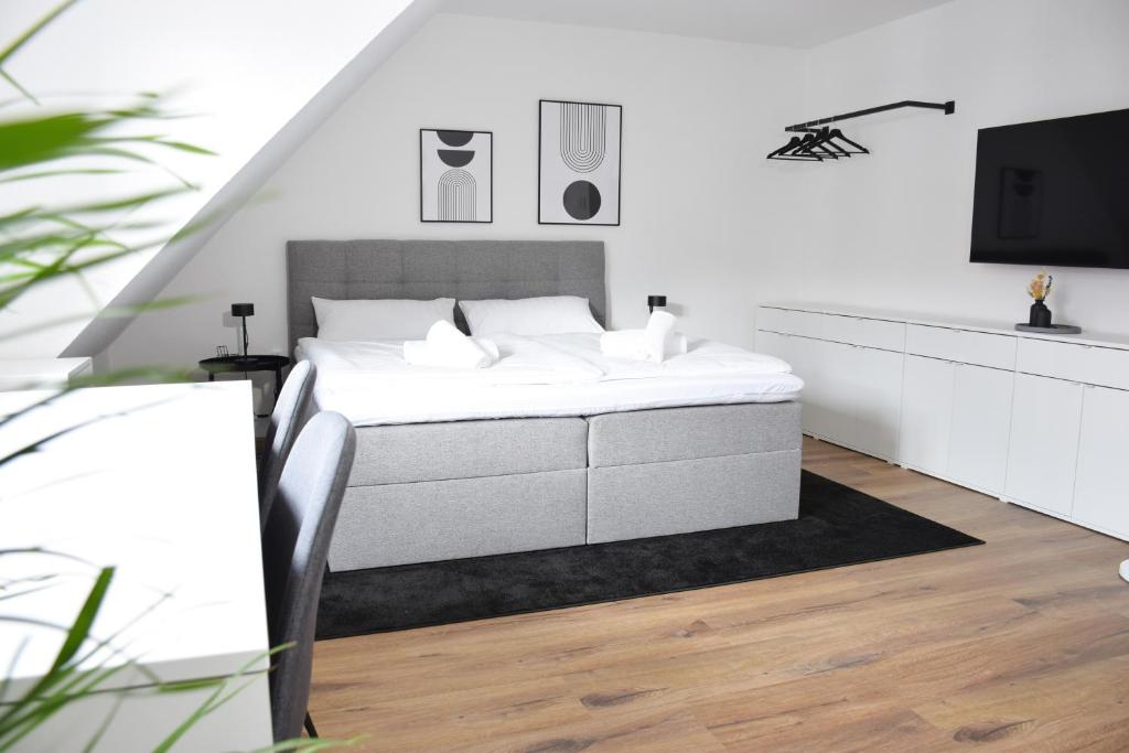 Un dormitorio blanco con una cama y un televisor. en stycoz - Modern studio - Central, en Kempten