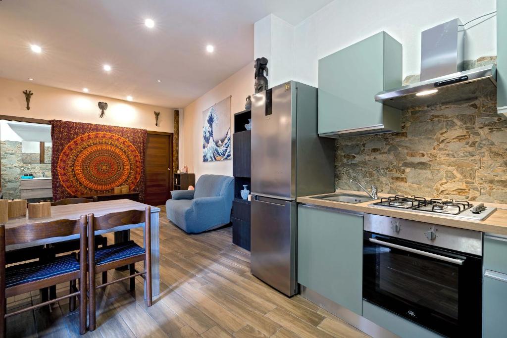 eine Küche und ein Esszimmer mit einem Tisch und einem Kühlschrank in der Unterkunft La piuma apartment in Quartu SantʼElena