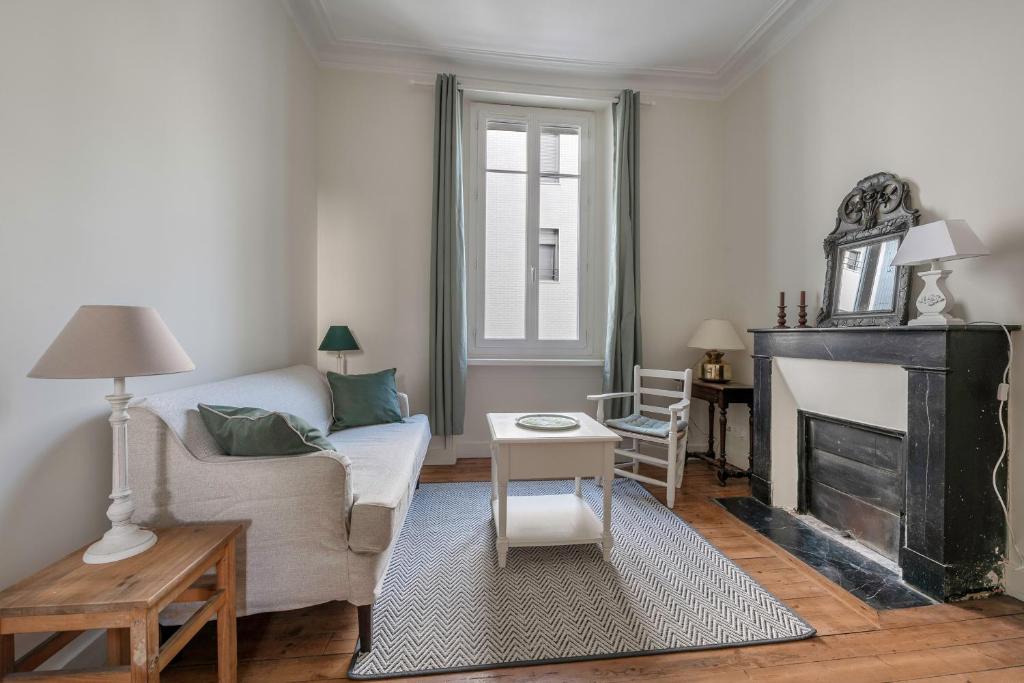 un salon avec un canapé et une cheminée dans l'établissement Appartement cosy pour 2, sur Nantes, à Nantes