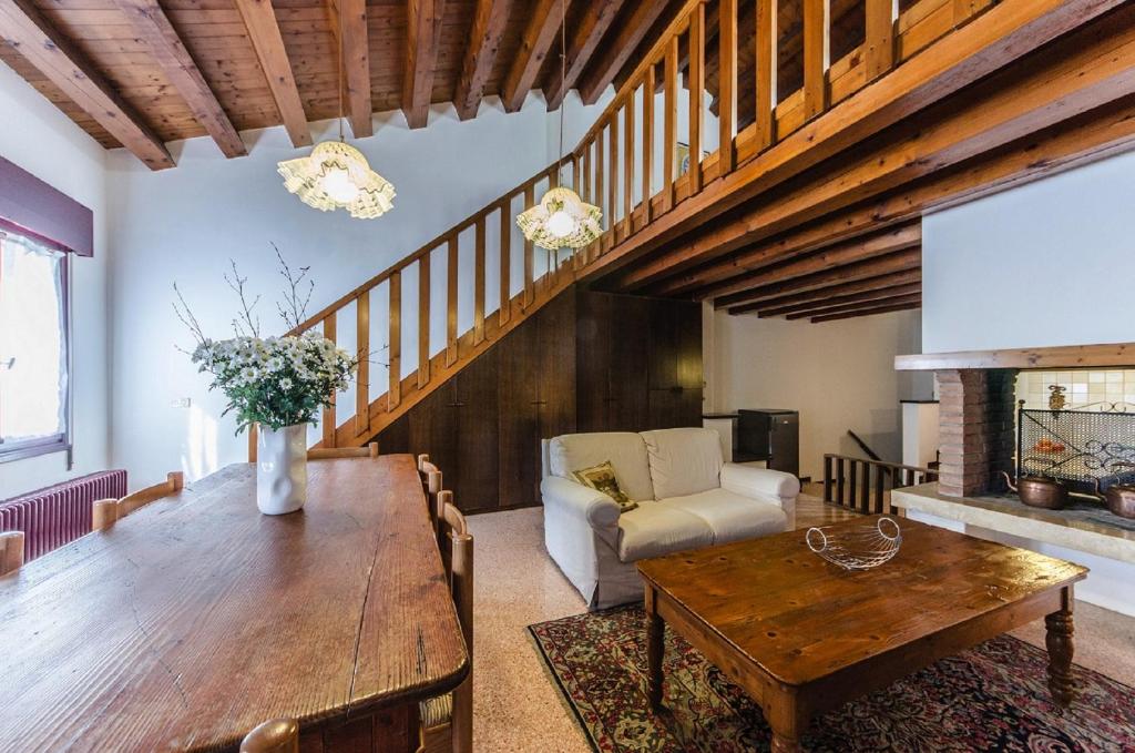 a living room with a wooden table and a couch at Novalesi Red House in Noale