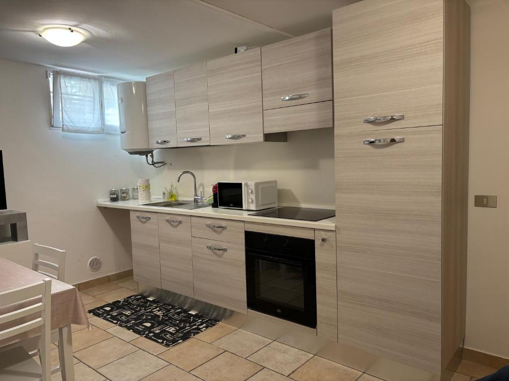 Una cocina con gabinetes de madera y microondas. en Appartamento Stella marina, en Pesaro