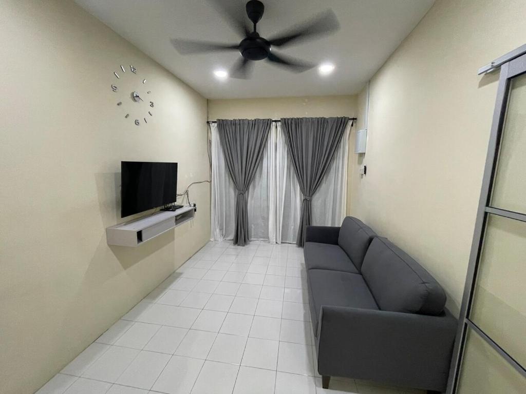 een woonkamer met een bank en een plafondventilator bij Qisa Guesthouse 03 in Arau