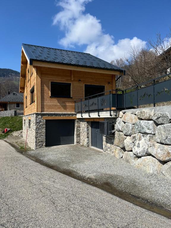 une maison avec un mur en pierre et un garage dans l'établissement La Biche, à Saint-Martin-sur-le-Chambre