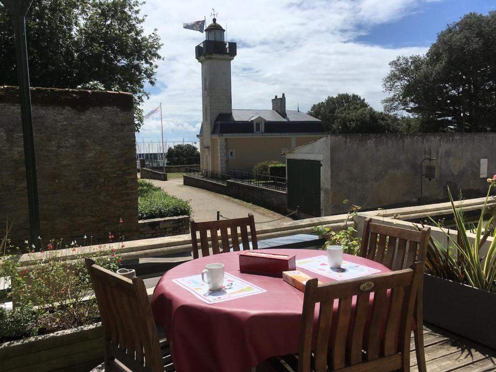 une table avec une nappe rose et un phare dans l'établissement KER MARY appartement lumineux 50 mètres de la plage, à Pornic