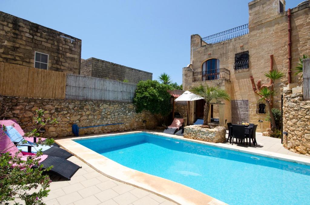 a swimming pool in front of a building at Ta'Peppa in Xagħra