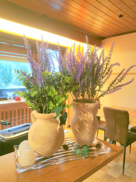 two vases sitting on top of a table with flowers at Fewo in Weierbach bei Idar-Oberstein in Idar-Oberstein