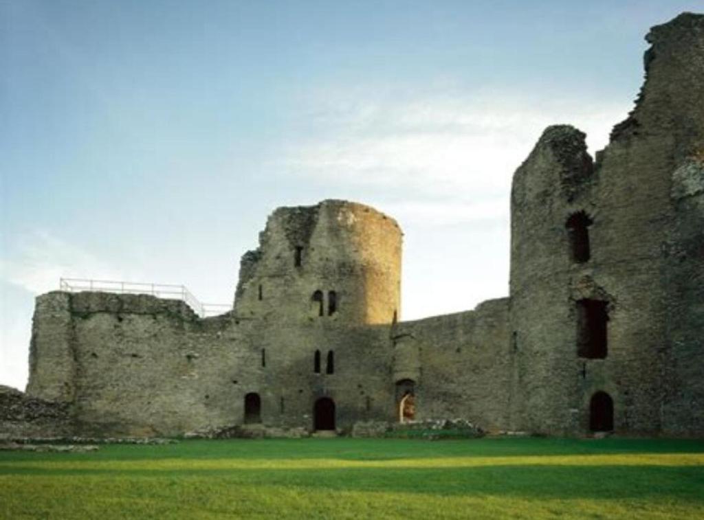 an old castle sitting on top of a lush green field at Cilgerran - cosy cottage in Cilgerran