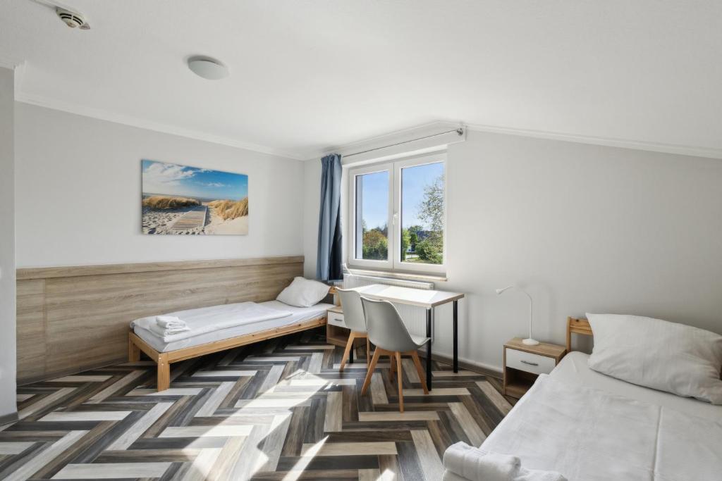 a bedroom with a bed and a desk and a window at Monteurwohnung in Kevelaer - WLAN, Küche, Waschmaschine & Parkplatz in Kevelaer