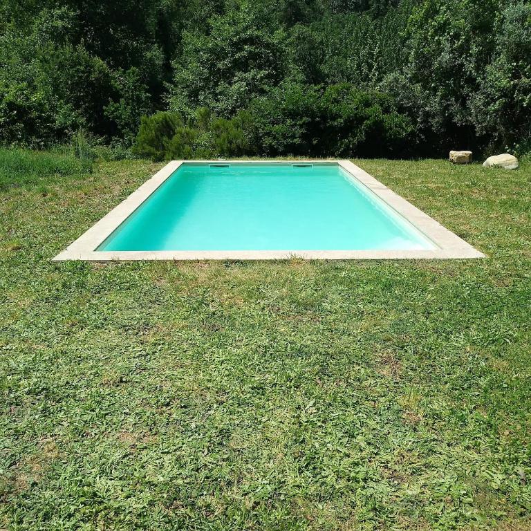 a swimming pool in the middle of a grass field at Casa do Faval in Senande