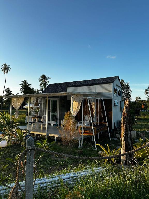 a small house with a porch and a fence at Beachfront Tiny House, Koh Samui, Thailand with FREE Rowboat in Nathon Bay