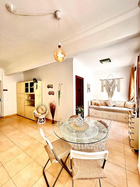 a living room with a glass table and chairs at T1 na 1 linha da Praia da Rocha in Portimão