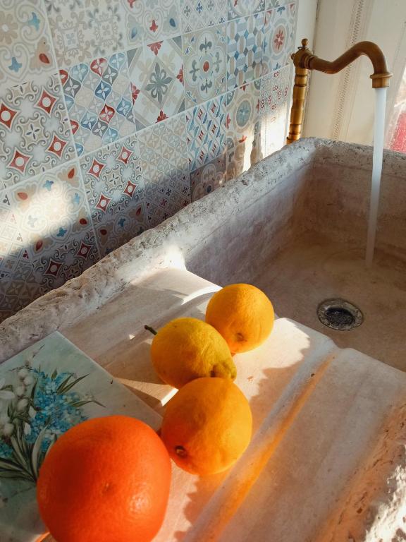 a group of oranges sitting in a sink at Message in a Bottle Bed and Breakfast in Camporosso