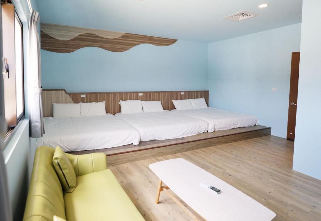 a bedroom with a large bed and a couch at 戀海輕旅Ocean Pride Hostel in Xiaoliuqiu