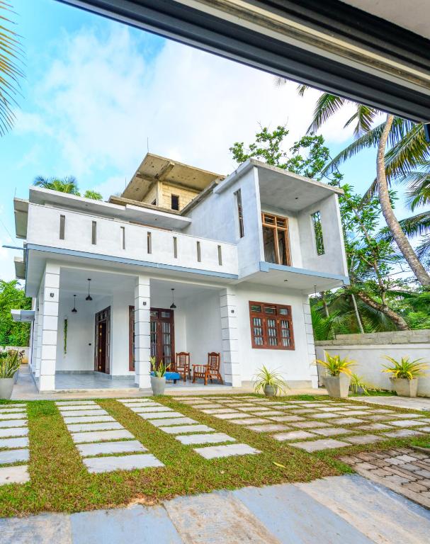 a white house with a courtyard in front of it at Caspiro Villa in Habaraduwa Central