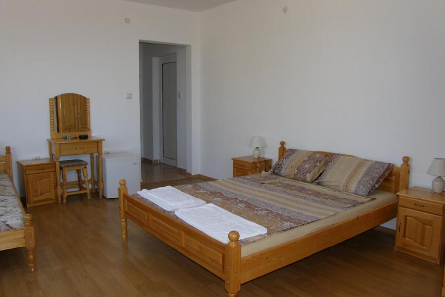 a bedroom with a bed and two tables and a chair at Prestige in Sinemorets