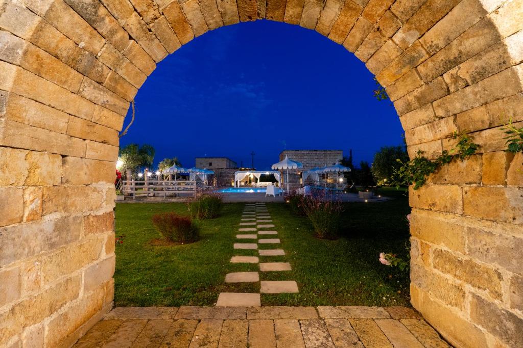 an arch in a brick wall with a walkway at Dimora Soleda in Torre San Giovanni Ugento